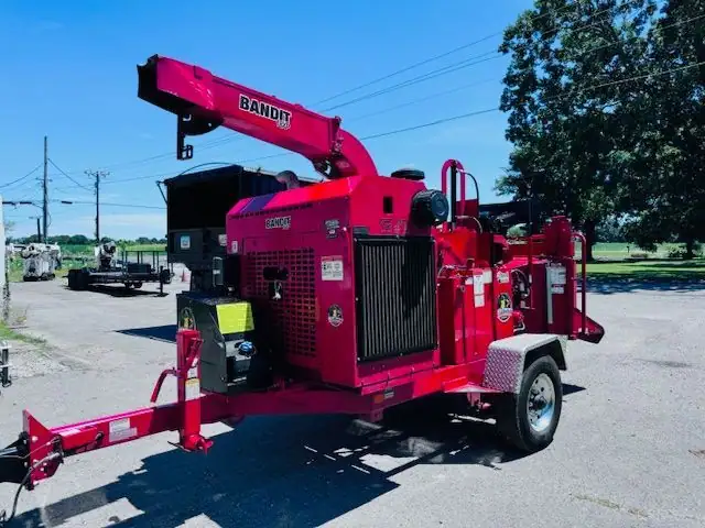 A red Bandit brush chipper parked on a paved lot