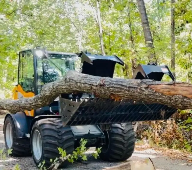 A wheel loader carrying a long log out of the woods
